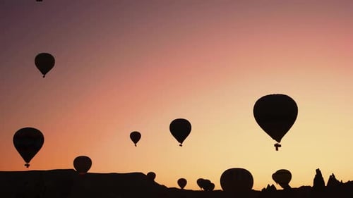 Hot Air Balloons Silhouetted at Beautiful Desert Sunrise