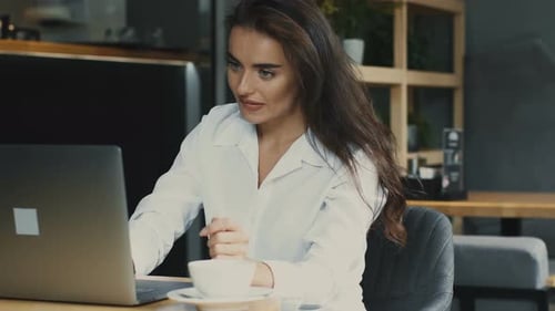 Woman Works on Laptop in Cafe, Stretches