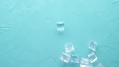 Close Up of Many Ice Cubes Drops on Blue Background
