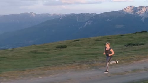 Woman Running on a Countryside Road at Sunset