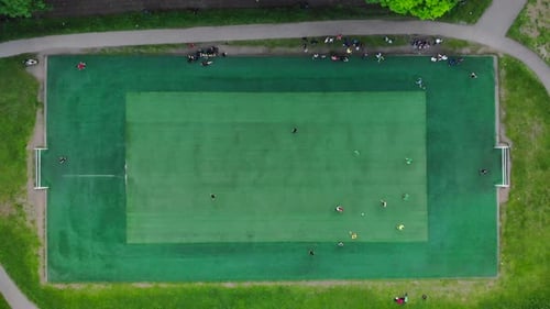 Aerial View of Men Playing Football on a Public City Soccer Field