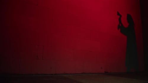 Creepy Death Silhouette Walking with Axe on Red Background
