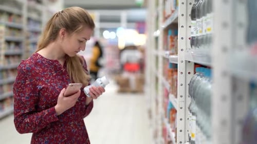 Attractive Young Woman Choosing Products in Supermarket Marketplace.