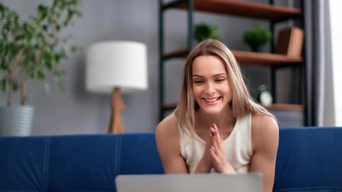 Woman Celebrates Success on Laptop at Home