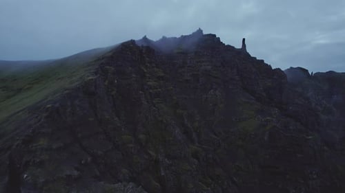 Drone Flight Over Mountain Peak Under Cloudy Sky