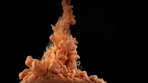 Orange Paint Flowing in Water on Black Backdrop