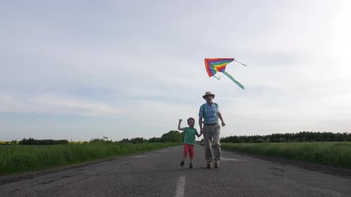 Adult and Child Running with Kite on Road