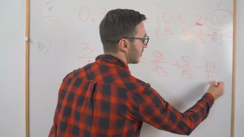 Man Solving Math Problem at Whiteboard