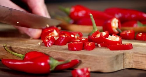 Chopping Fresh Red Chili Peppers on Cutting Board