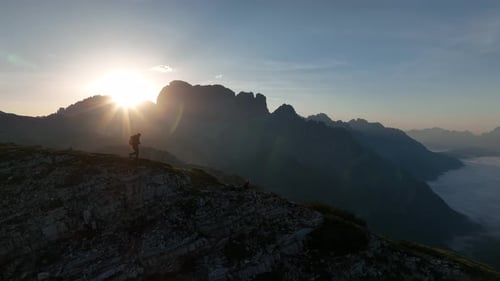 Female and male hikers at the top of the mountain at sunrise.