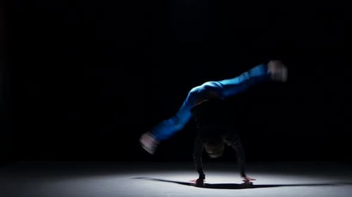 Young Man Breakdancing Under Spotlight in Studio