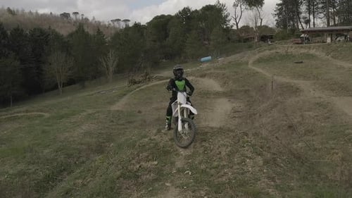 Motocross Rider on Dirt Bike in Rural Landscape
