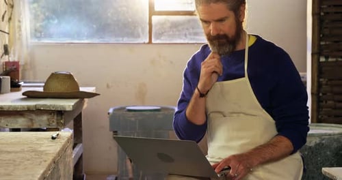 Potier masculin utilisant un ordinateur portable