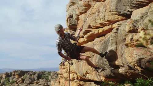 Mountaineer rappelling down the hill with the help of rope