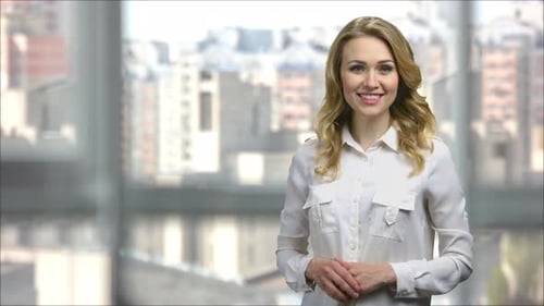 Blonde Businesswoman Presenting in Front of City Window