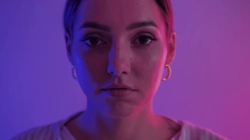 Woman's face portrait in blue and pink light