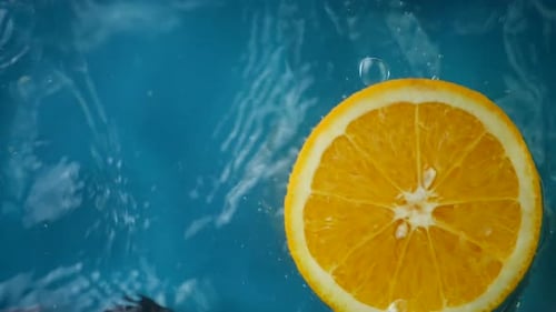 Geschnittene Orangenspritzer in Wasser