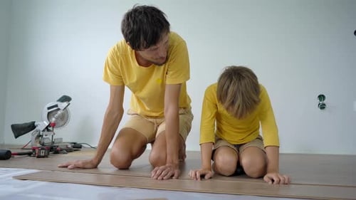 Father and Child Laying Laminate Flooring Together