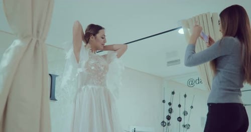 Linda garota experimentando um vestido de noiva