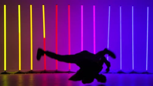 Breakdancing Acrobatic Elements Performed By a Professional Dancer Against the Backdrop of Bright