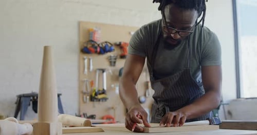 Carpenter Measuring Wood Piece in Bright Workshop