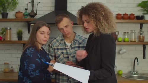 Pretty Woman Realtor Showing Real Estate Agreement to Couple of Potential Buyers
