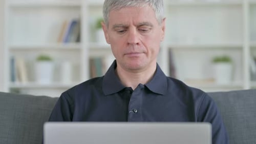 Adult Man Smiling and Using Laptop