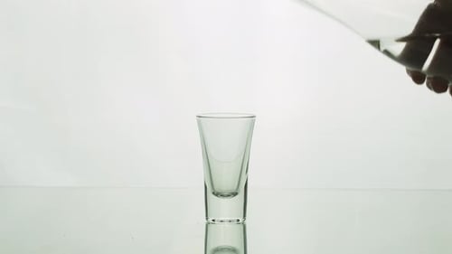 Clear Liquid Poured into Empty Shot Glass
