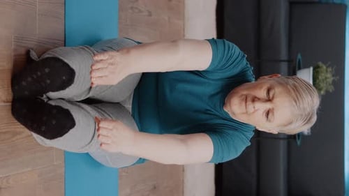 Senior Woman Exercising Indoors on Exercise Mat