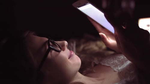 Side View of a Happy Teen Browsing and Watching Media in a Smart Phone Lying on