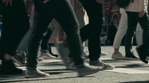 crowd of people walks down the street of the city