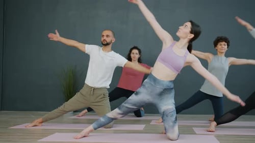 Active Young People Exercising in Sports Center Doing Yoga Together on Mats