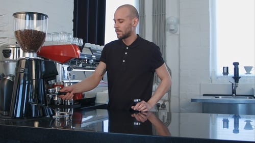 Young Adult Man Makes Coffee in Coffee Shop