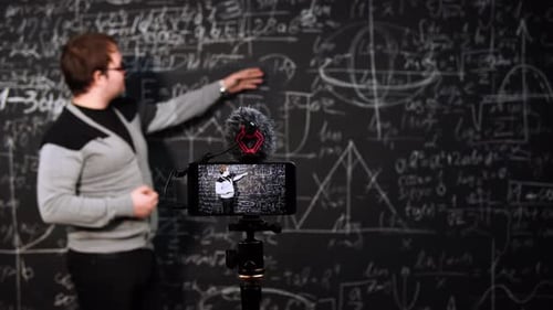 Enthusiastic Teacher Explaining Math in Front of Blackboard