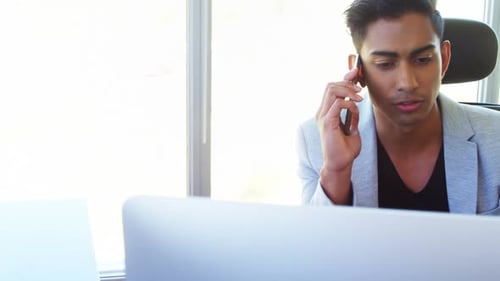 Young Adult Talks on Mobile Phone in Workplace