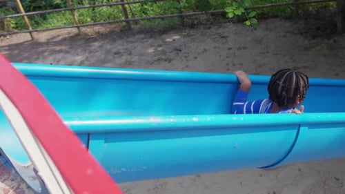 24K Little African boy sliding and playing at playground in the park