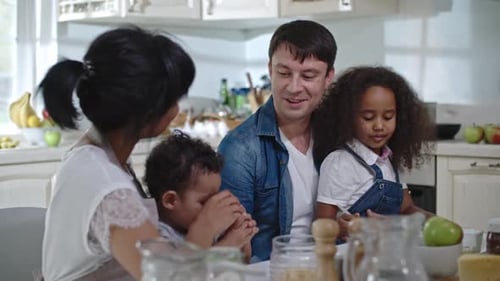 Family Together at Table in Modern Kitchen