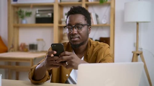Adult Man Using Smartphone at Desk Indoors