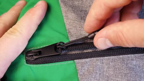 Verschließbarer Reißverschluss auf grüngrauem Stofftuch