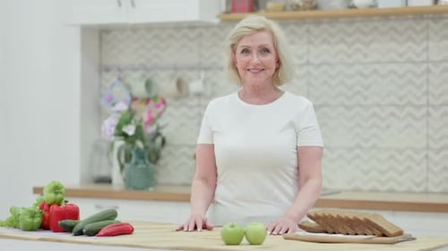 Woman smiling in kitchen with healthy food