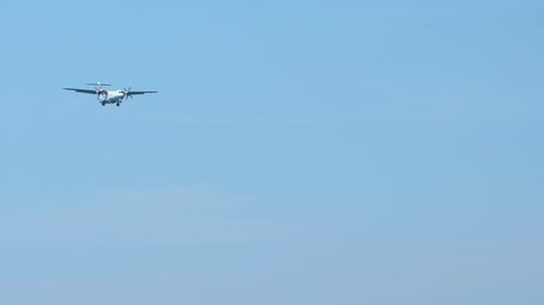Airplane flying through bright blue sky during the day