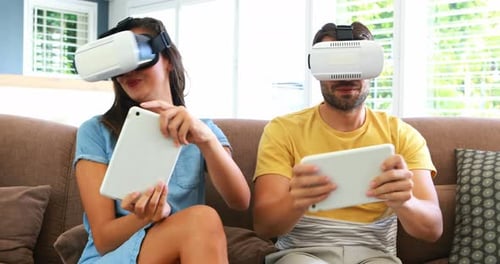 Couple Using VR Headsets with Tablets on Couch