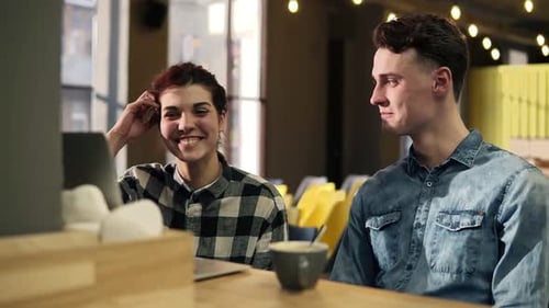 Young Adults Using Laptop in Modern Cafe