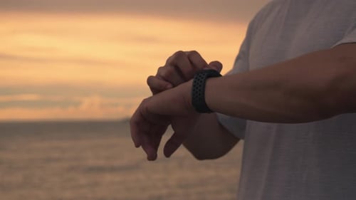 Close up Asian athlete runner checking heart rate on smartwatch after running.