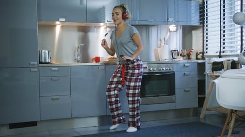 Happy Woman Dancing and Singing in Kitchen