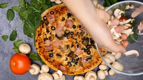 Adding Sliced Mushrooms to Fresh Pizza