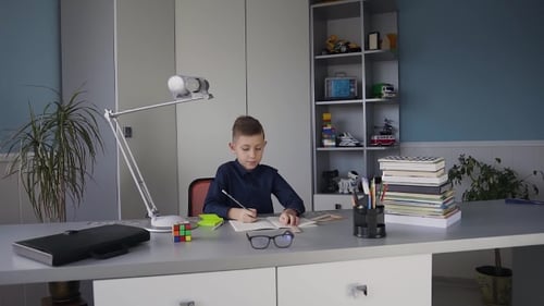 Boy Writing at Desk Indoors