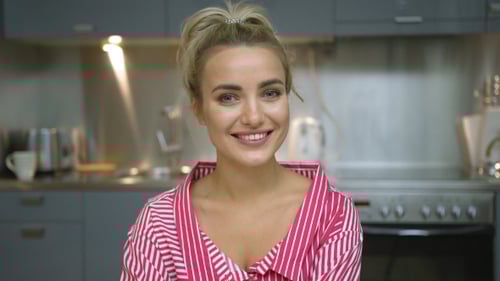 Smiling Woman in Kitchen Looking at Camera