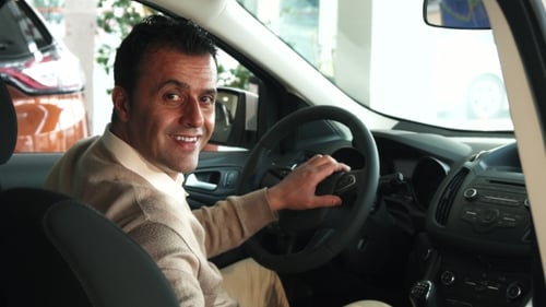 Man Sitting in Car at Dealership