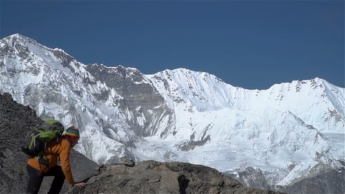 The Tourist Climbs the Cliff in the Himalayas